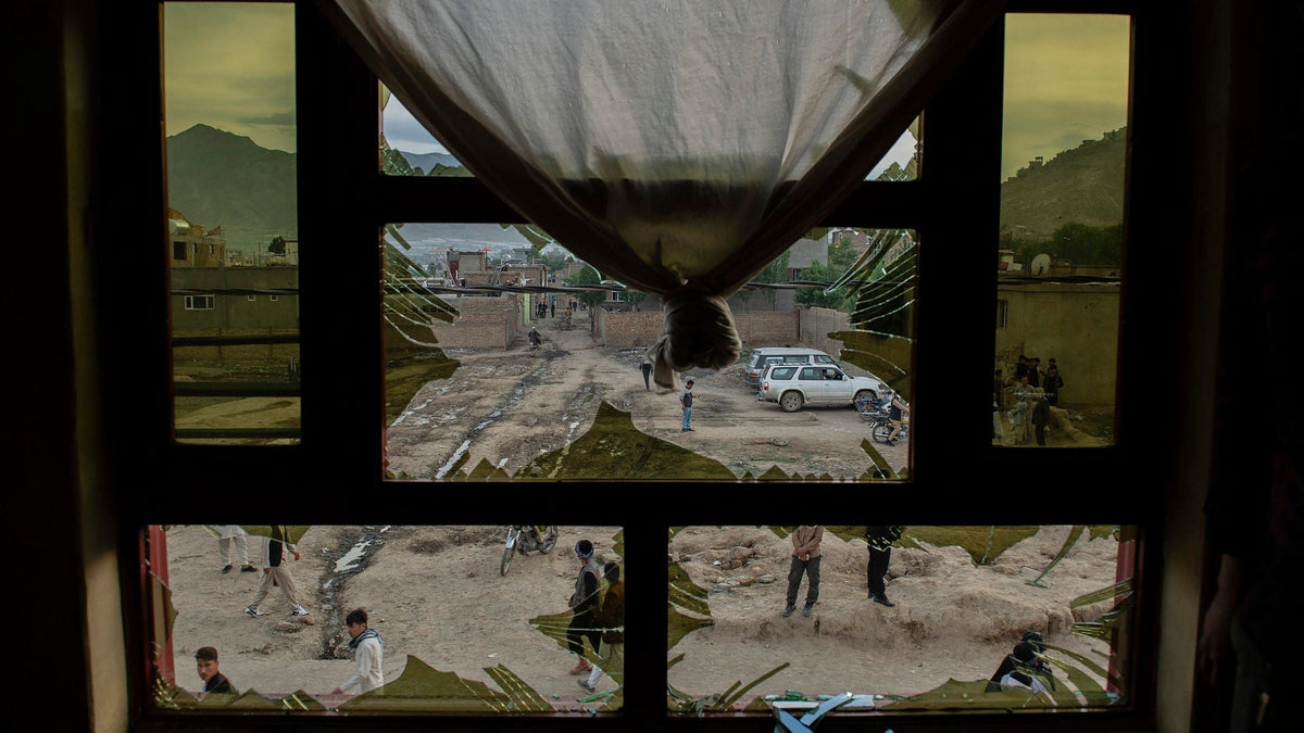 Broken window with shattered glass overlooking a street in Afghanistan.